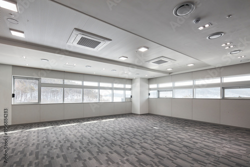 Photography Bright vacant room with patterned carpet and continuous window band