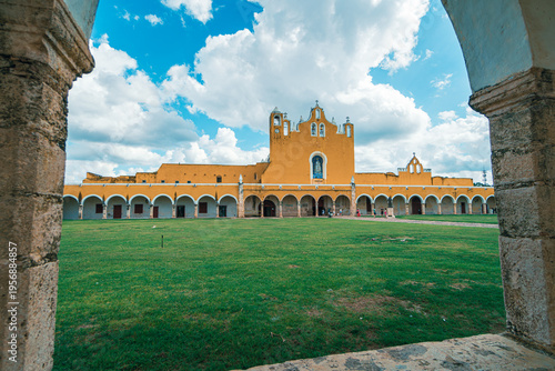 Yellow church framed by stone archway