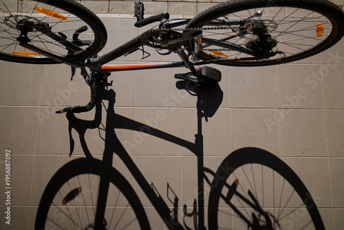 Top view of bicycle casting shadow on sunlit pavement outdoors. Concept of cycling urban transport and active lifestyle