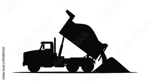 Dump truck unloading materials a striking black silhouette