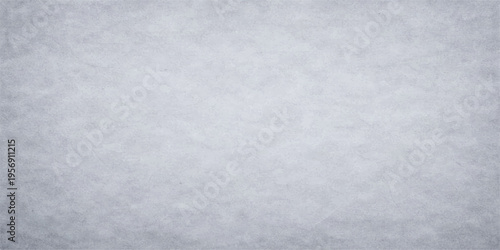 A serene expanse of freshly fallen snow blankets the landscape.A blank grunge paper texture with a rough stone surface resembles a cold winter snow pattern on an old gray cement wall backdrop