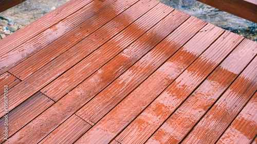 Close up of wet wooden deck boards with raindrops during rainfall