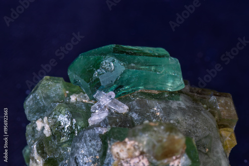 Raw green Tsavorite garnet, from Tanzania, on host rock. Black background. 

