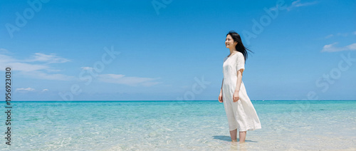 Authentic woman walks on a pristine beach with crystal water summer vibes