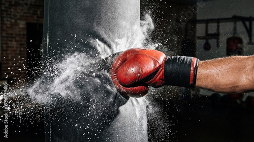Wallpaper Mural Mans red boxing glove punching heavy bag at high speed. Dust exploding from impact during intense gym training. Combat sports power and fitness motivation concept Torontodigital.ca