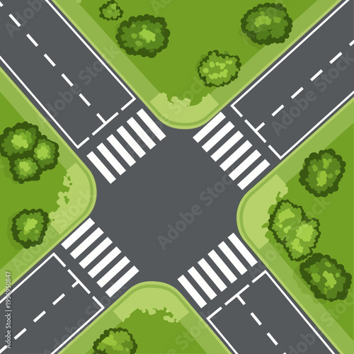 Top view of a crossroad intersection with pedestrian crossings and green spaces