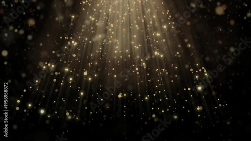 Glowing gold particles floating down with light rays on black background video footage