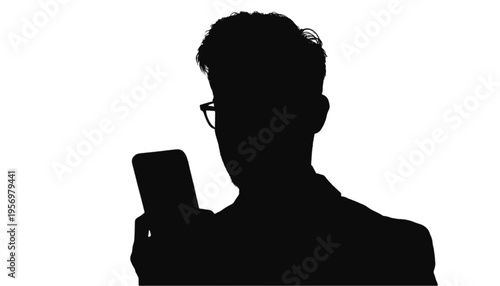 Silhouette of a man wearing glasses intensely focusing on a mobile phone screen against a white background.