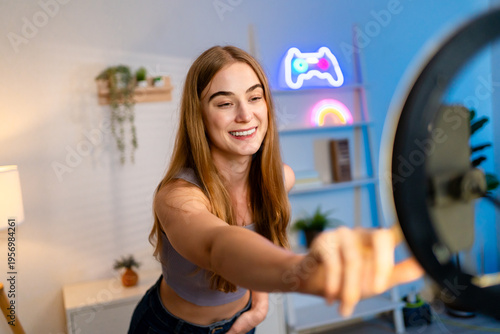 Caucasian woman content creator recording video on mobile phone in house. 