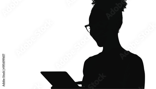 Silhouette of a smiling young woman wearing glasses while looking down at a digital tablet.