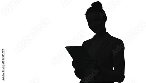 Silhouette of a businesswoman holding a digital tablet device while standing ready for work in a stark white.