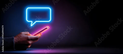 A persons hand holds a glowing smartphone with a vibrant blue neon message icon above it in a dark digital space