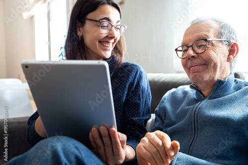 Canvastavla Young woman teaching elderly man using digital tablet
