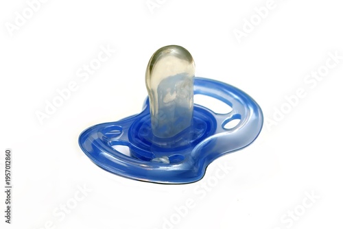 Close-up of a translucent blue pacifier. The design features circular cut-outs, and it sits against a plain white background
