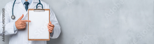 Medical professional in white coat holds blank clipboard, pointing at it with stethoscope around their neck. background is soft gray, creating professional atmosphere
