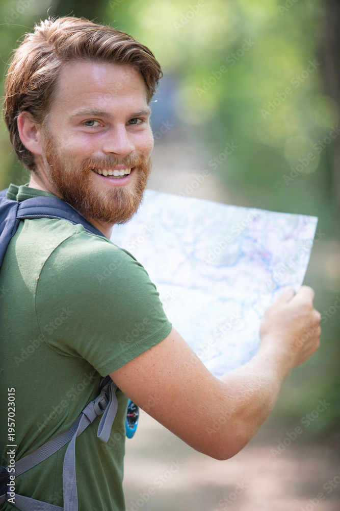 Fototapeta premium young handsome hiker using map in the nature