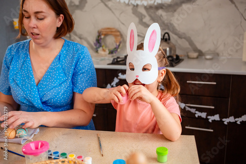 Caucasian mother and daughter preparing for Easter by coloring eggs, building memories and spending meaningful time. Concept of family traditions, childhood and festive preparation. Mid shot