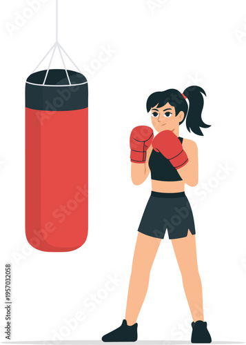 A woman in boxing gloves standing next to a punching bag