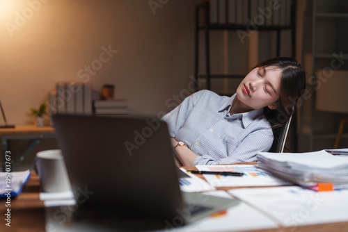 Overworked businesswoman sleeping at desk after long night