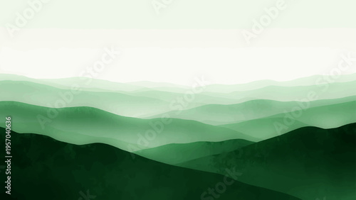 A misty blue mountain range at dawn with fog and clouds settled in the valley under a soft sunrise sky