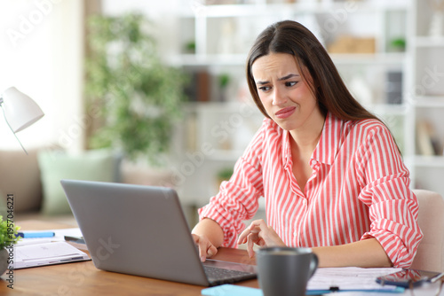 Fotografie Disappointed self employed checking laptop online content