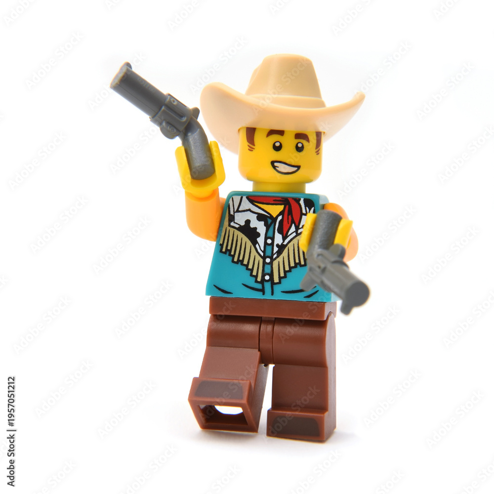 Naklejka premium Lego minifigure of Cowboy in costume with hat is playing with two guns. Editorial illustrative image of popular children toys.