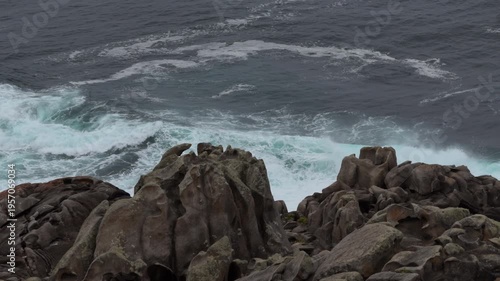 Slow motion rugged coastal cliffs with crashing waves and sea spray