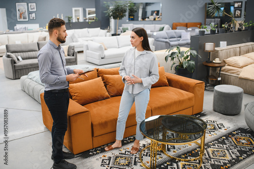Female client consulting male sales consultant in furniture shop