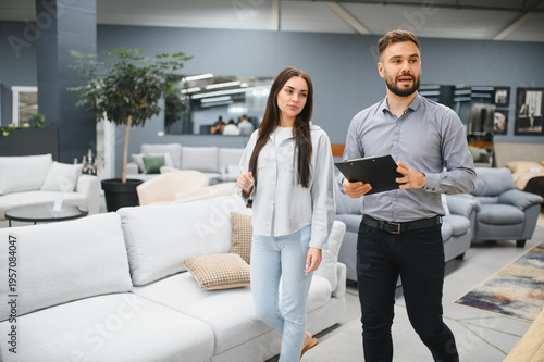 Obraz na plátne Salesman consulting female customer in furniture store