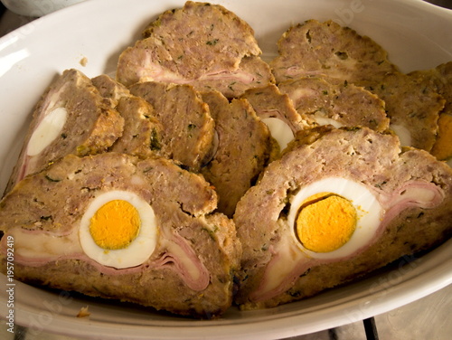 Polpettone fatto in casa con uova sode al centro, tagliato a fette per mostrare il ripieno. 
Ricetta rustica Italiana