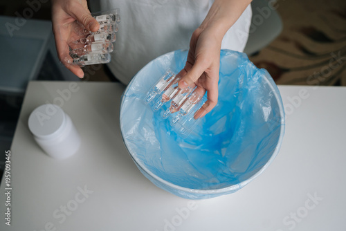 Obraz na plátne Top view of person hands dropping multiple glass ampoules of expired medication