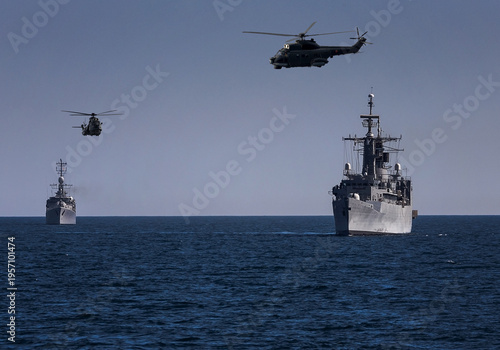 A group of patrol warships accompanied by a helicopter are carrying out a peacekeeping mission in the mediterranean sea. Battleships in action.	