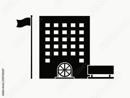 A large building with a flag and a car parked outside shows industry