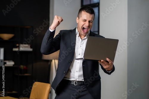 Photos Male professional cheering and showing victory gesture after successful work mom