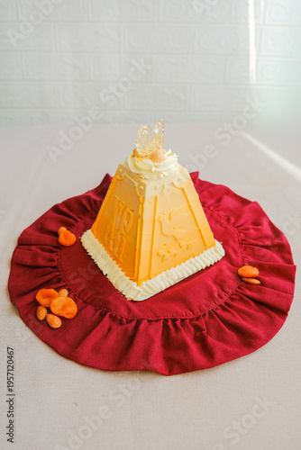 фотографія Traditional Orthodox Easter paskha curd cake decorated with dried apricot on red textile