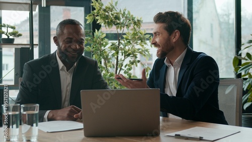 Bild auf Leinwand Diverse men colleagues business team sharing ideas laptop work discussing in off