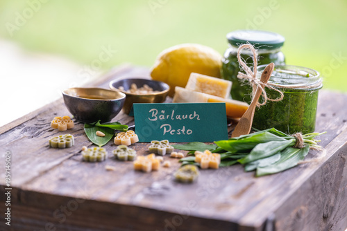 Foto Frisches selbstgemachtes Bärlauchpesto dekoriert mit Bärlauchblättern, Hartkäse,