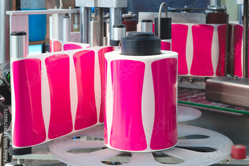 Photography Pink adhesive labels roll on automated machinery