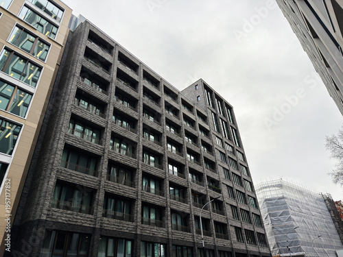 Modern brick apartment and office building facade in London, UK under overcast sky