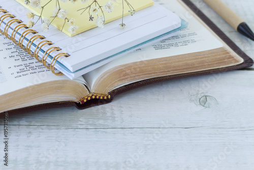 Holy bible and notebook on wooden background. Scripture study and reading, biblical concept. Copy space. Close-up. Selective focus.