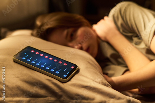 Quadro su tela Teenage girl lying on bed looking at smartphone screen with multiple missed call