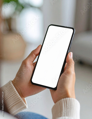 Hand holding smartphone mockup with white screen for design and copy space.
