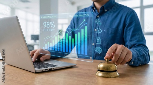 Man gestures toward digital graph at desk. Hand taps bell beside laptop. Screen shows 98% growth and upward trend