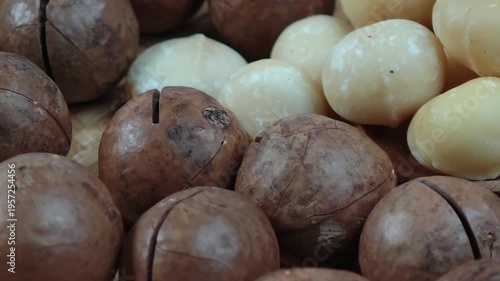 Macadamia nuts are in a wooden plate.