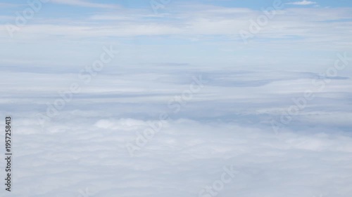 Aerial view above the clouds and sky inspiration concept in cinematic breathtaking aerial flying over white fluffy cloudscape in high altitude sky with fresh clean air and blue skies on background.
