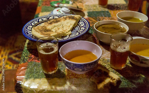 2 glasses of traditional Moroccan Mint Tea, served along with warm flat bread used for dipping in honey or Amlu - a thick brown dip consisting of roasted almonds and argan oil 