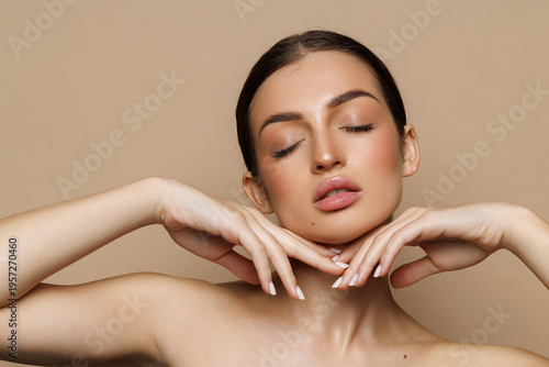 Beautiful young woman with clean fresh skin on beige background,
