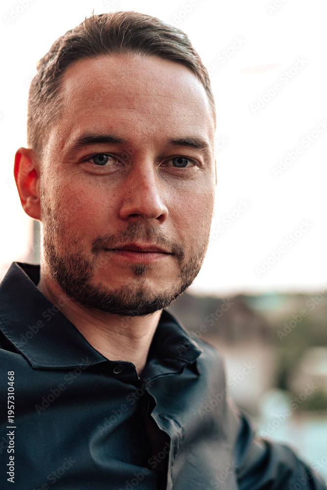 Fototapeta premium Man sits in outdoor setting with soft lighting during sunset in a casual moment