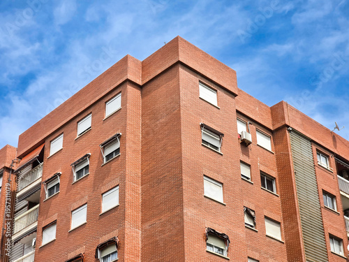 Modern red brick apartment building exterior, contemporary modern residential architecture in urban neighborhood in Valencia Spain