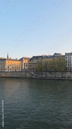 Seine River Cruise Boat Passing Historic Buildings at Sunset in Paris France